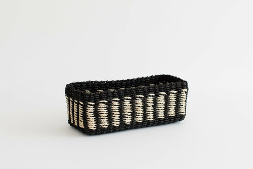 Halden woven seagrass tray with black band, photographed on a warm neutral surface