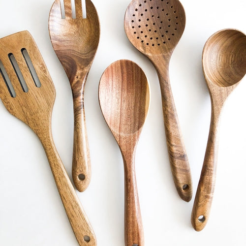 Fenwick acacia wood kitchen utensil set, photographed on a warm neutral surface
