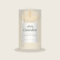 Cawden vanilla bean soy candle in a clear glass jar with the Osterly label, lit, on a warm neutral background