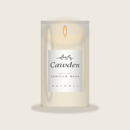 Cawden vanilla bean soy candle in a clear glass jar with the Osterly label, lit, on a warm neutral background