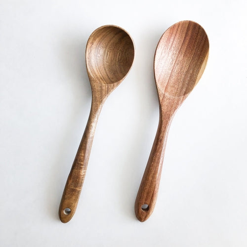 Fenwick acacia wood kitchen utensil set, photographed on a warm neutral surface