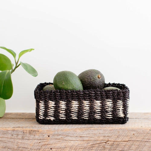 Halden woven seagrass tray with black band, photographed on a warm neutral surface